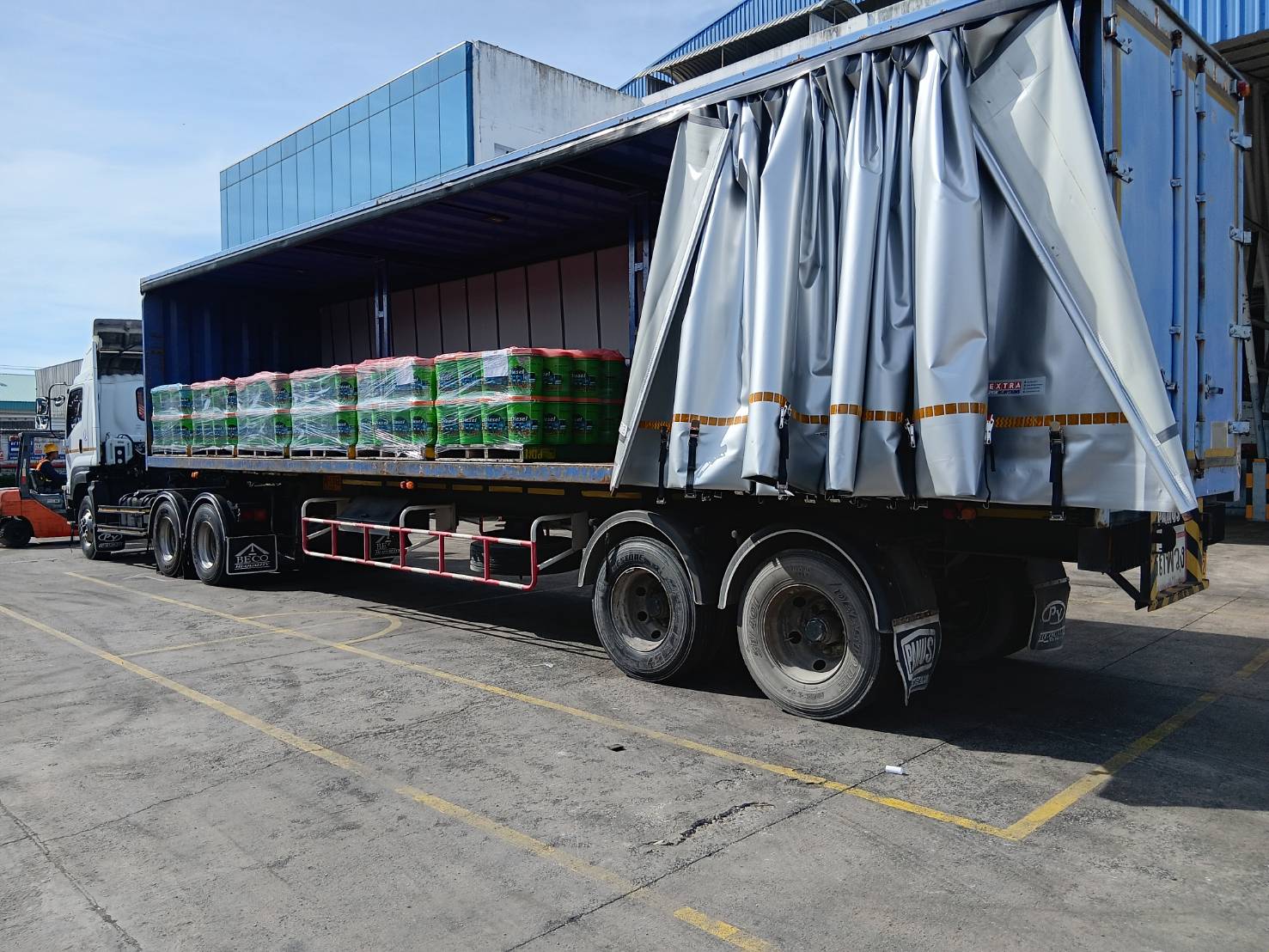 Large truck with covered cargo and palletized goods - professional freight service